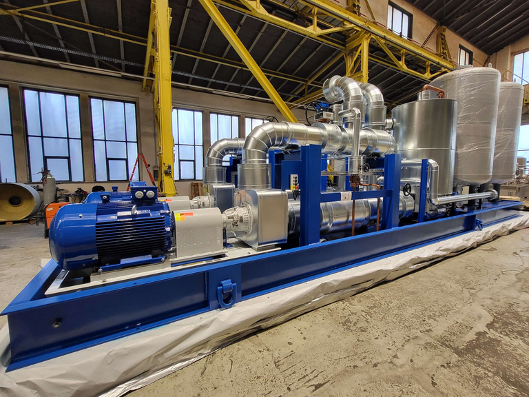fertig montiertes Pumpenumwälzsystem mit blauem Grundrahmen und metalischen Verrohrungen, in einer Fertigungshalle