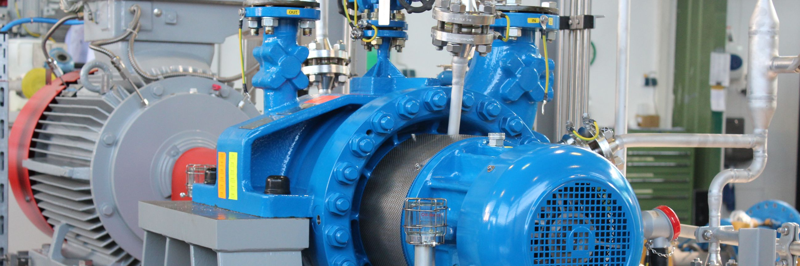 Technische detailaufnahme eines BB2 Pumpenaggregates mit Verrohrung, Elektromotor und technischen Zubehör zum Einsatz in einer Raffinerie.