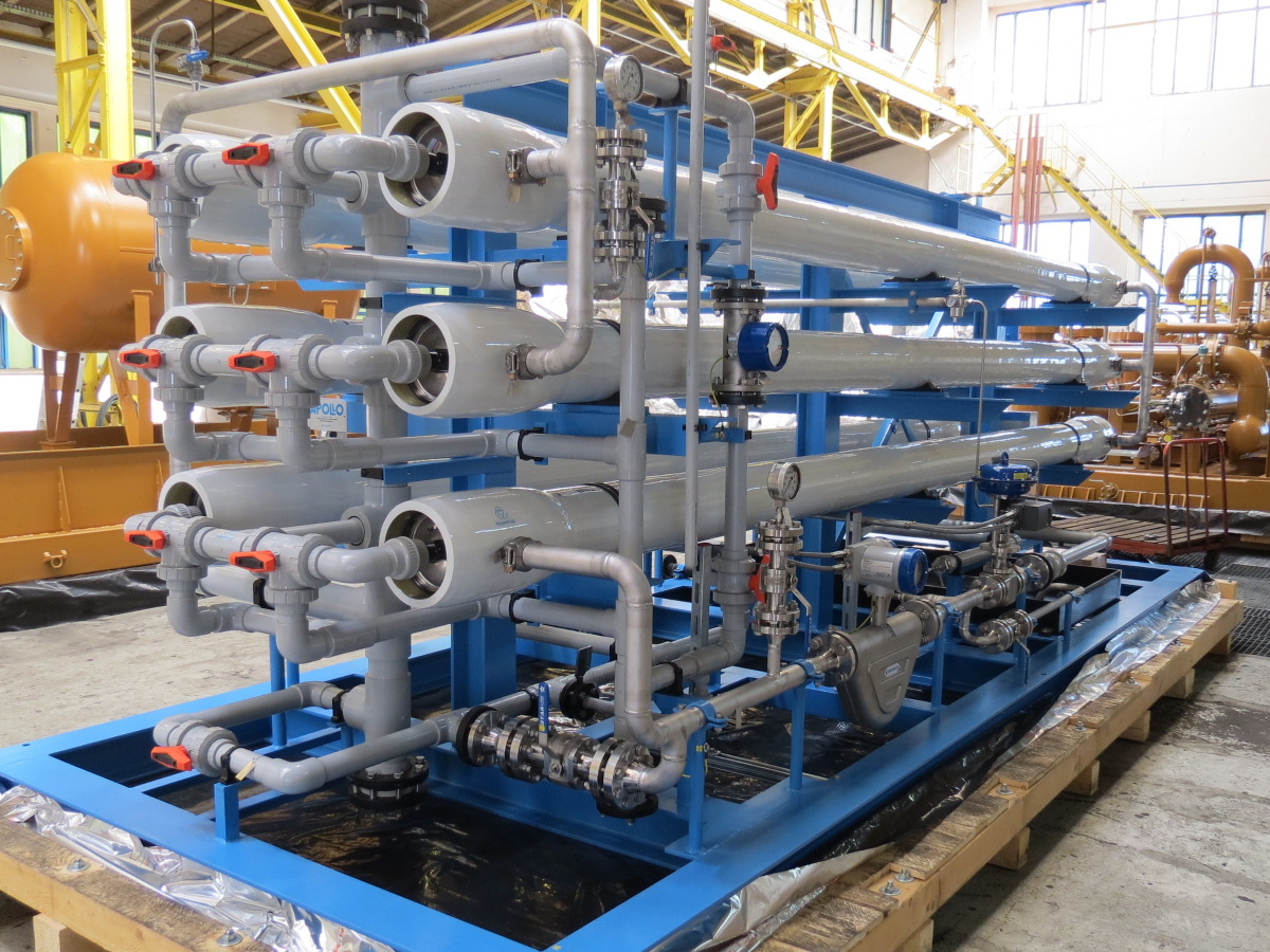 Zu sehen ist eine Detailaufnahme eines Sulfate-Removal-Skid, das auf einem hölzernen Verpackungsboden in der Halle von Apollo steht.