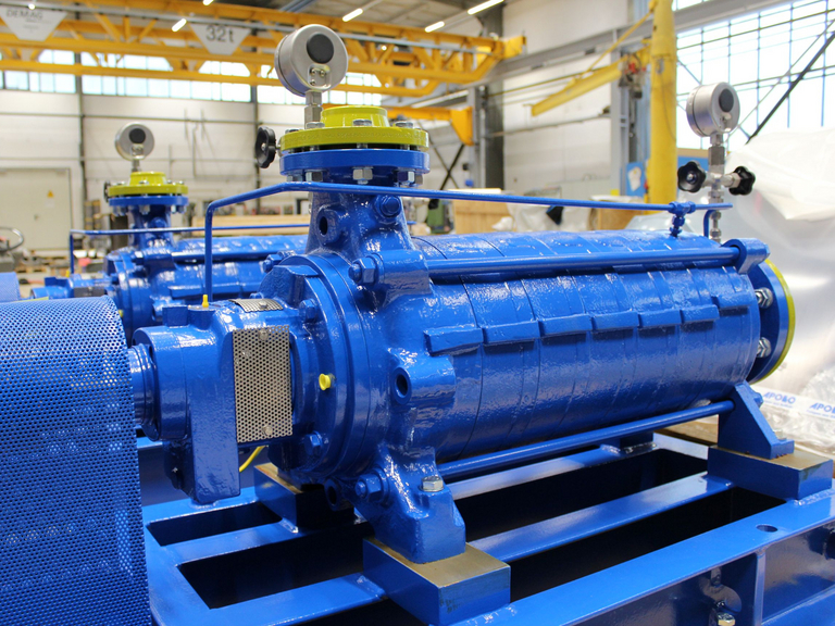 Seitliche Nahaufnahme einer blaulackierten Apollo mehrstufigen GLZ Gliederpumpe. Im Hintergrund sind Elemente einer Fertigungshalle mit gelb lackierten Stahlträgern zu sehen.