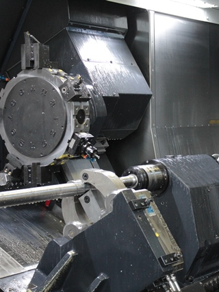 CNC-Maschinenbediener in der Metalltechnik bei der Bearbeitung von Wellen