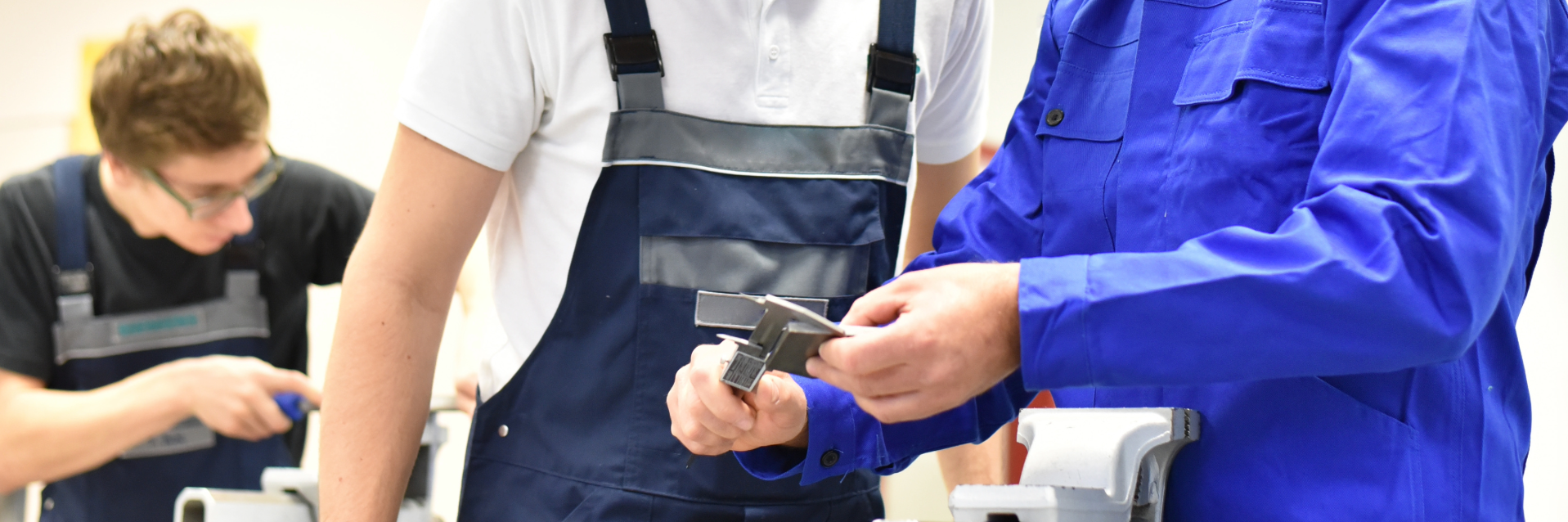 Eine Gruppe von Auszubildenden in der Lehrwerkstatt bei der gemeinsamen Arbeit