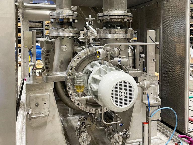 The front view shows a soundproof enclosure in which a BB2 pump is connected to a pipe. The pump is undergoing a functional test on the Apollo test field.