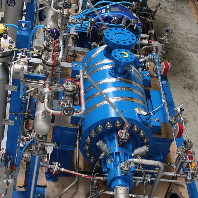 Blick von Oben auf ein BB5 Pumpenaggregat welches verrohrt und verkabelt ist für Schmierölsystem, Überwachungssystem sowie Kühlsystem; Pumpengehäuse ist Dunkelblau lackiert.