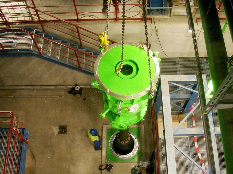 Blick von oben auf eine vertikale Pumpe der Baureihe „Apollo GLKV” während der Installation in einem Kraftwerk. Die am Kran aufgehängte Pumpe wird in den Pumpentopf eingesetzt.