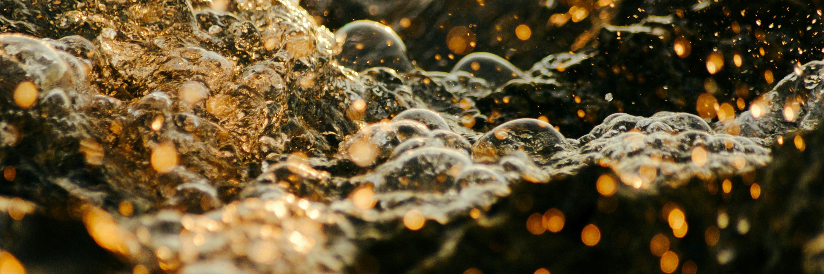 It is an effervescent mixture of water and oil with air bubbles in a light brownish orange color.