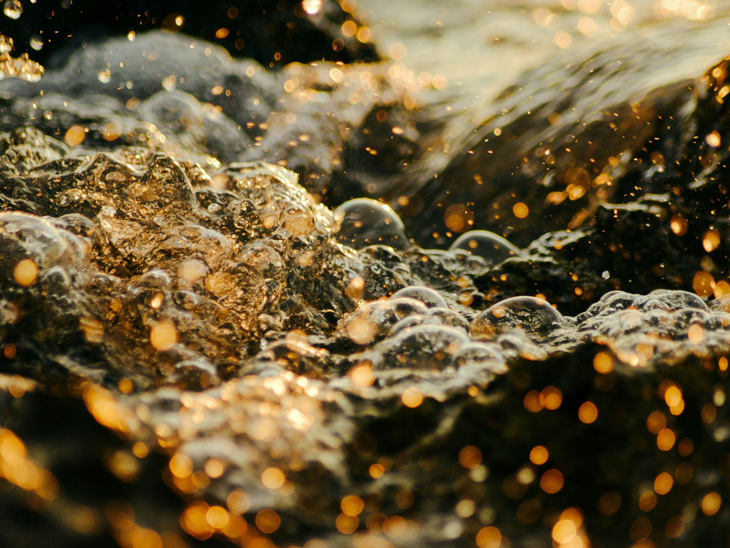 It is an effervescent mixture of water and oil with air bubbles in a light brownish orange color.