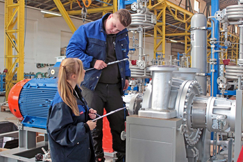 zwei junge Personen kontrollieren Pumpenskid