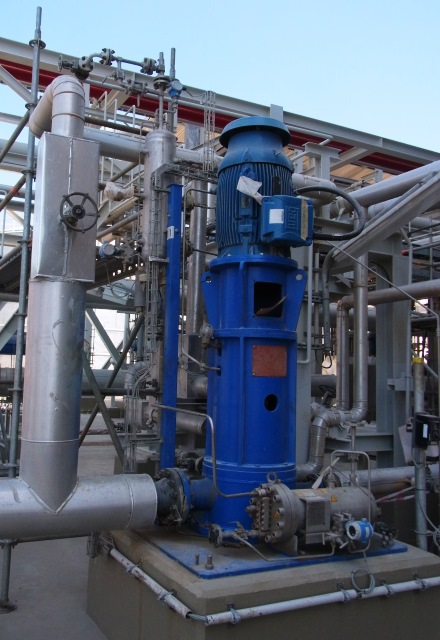 In einer Düngemittelanlage mit vielen Verrohrungen, Leitungen für Flüssigkeiten und Gasen ist eine vertikale Apollo Prozesspumpe vom Typ HPTV (VS6) auf einem Betonfundament installiert..