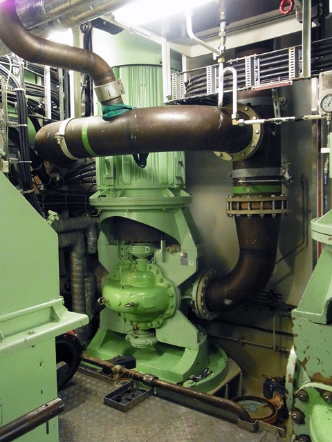 Blick in den Maschinenraum eines Schiffes, in dem eine ZMKV eingebaut ist. Dabei handelt es sich um eine vertikale, axial geteilte und einstufige Pumpe mit beidseitiger Lagerung, die grün lackiert ist.